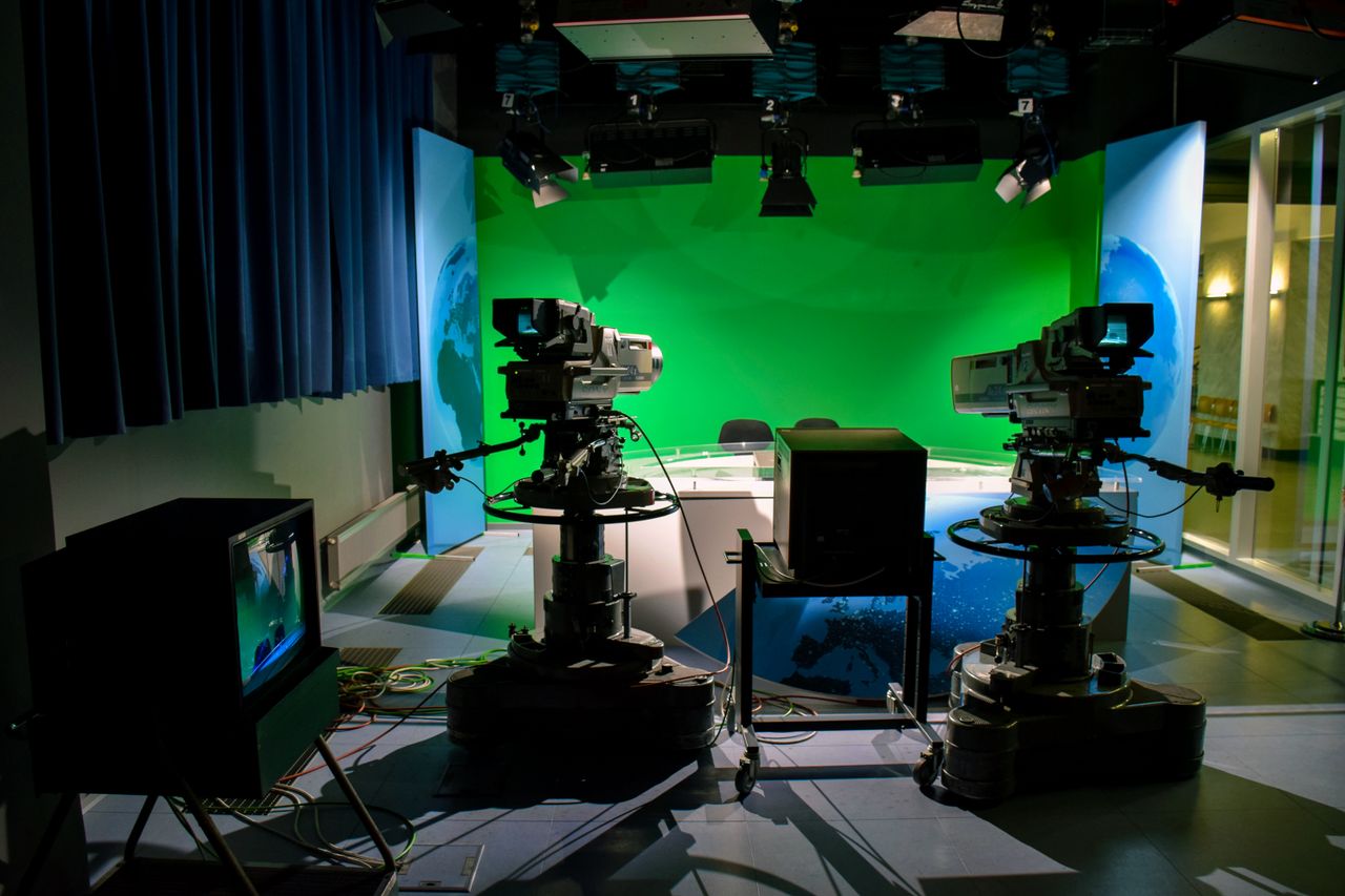 Services A TV studio setup featuring cameras and a green screen for production purposes.